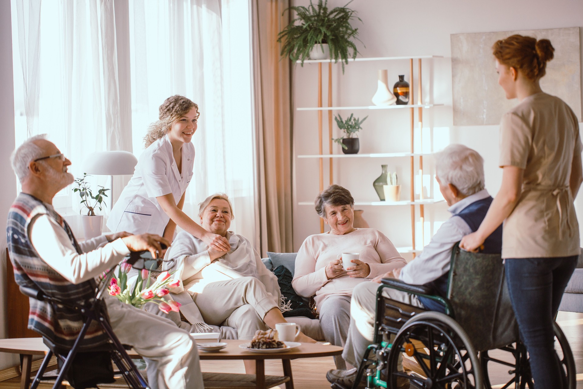 Disabled grandparents spending time in common room with their caregivers